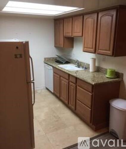 A kitchen with brown cabinets and a refrigerator.