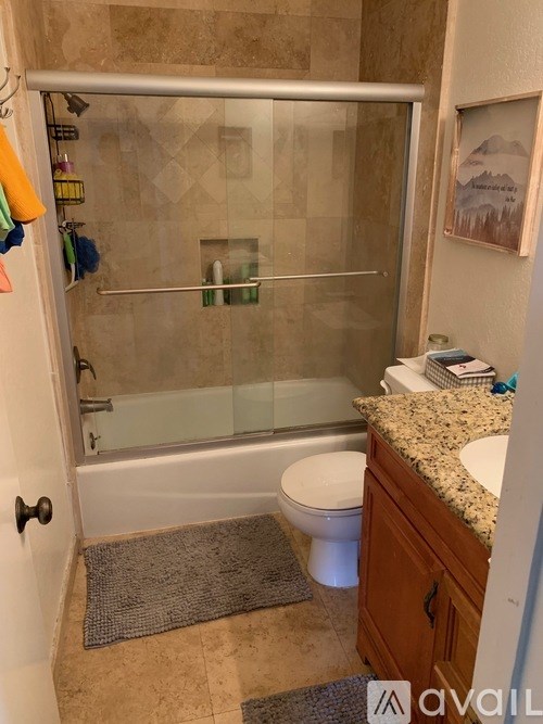 A bathroom with a toilet, sink, and shower.