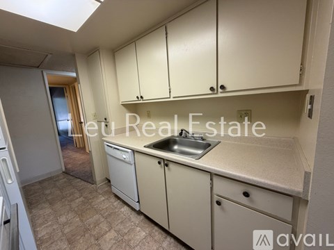 A kitchen with beige cabinets and a sink.