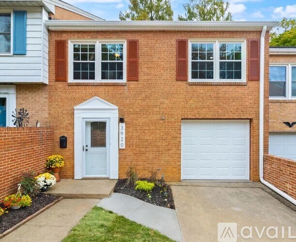 A brick house with a white garage door and a white door with a glass window.