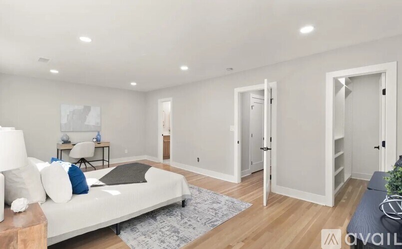 A modern living room with a white sofa and a grey rug.