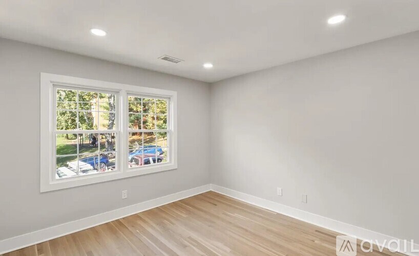 A room with a large window and wooden flooring.