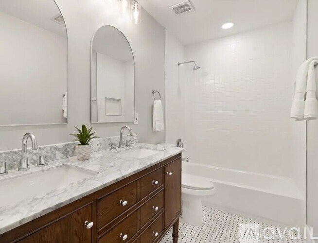 A bathroom with a marble countertop and a white tiled floor.