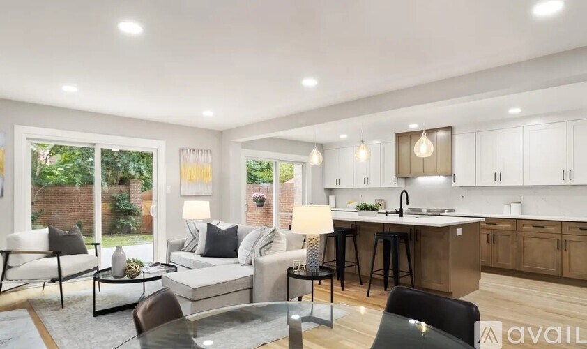 A modern living room with a kitchen area in the background.
