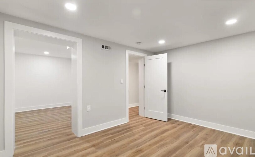A room with a white door and a white wall.