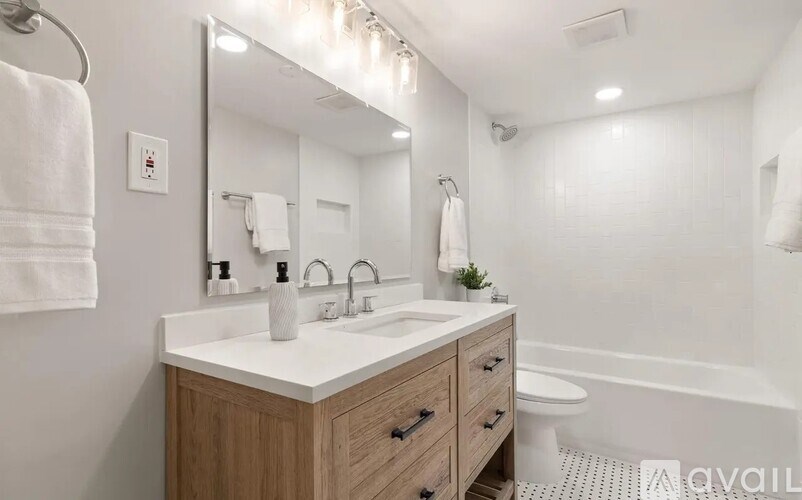 A bathroom with a white countertop and a white towel hanging on the wall.