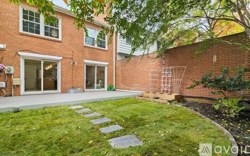 A brick house with a green lawn in front.