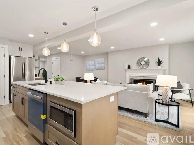 A modern kitchen with a large island and a fireplace in the living room.