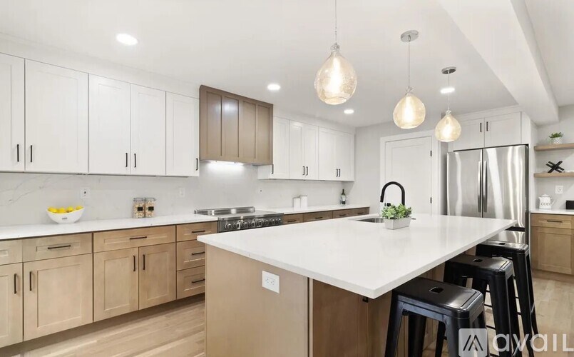 A modern kitchen with a white countertop and wooden cabinets.