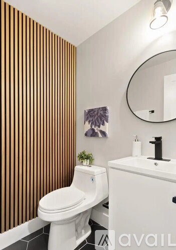 A white toilet sits next to a white sink in a bathroom.