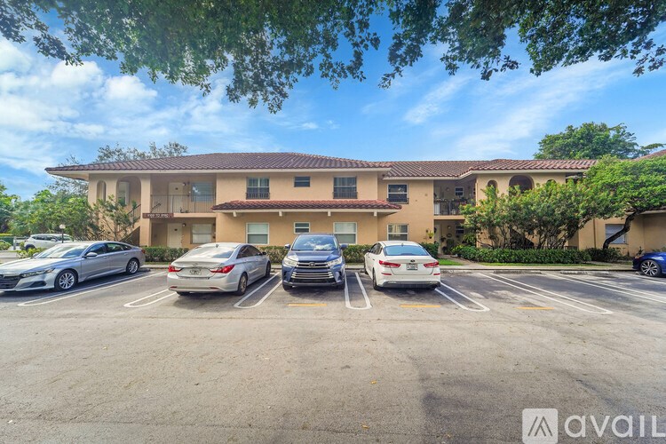 A parking lot with several cars parked in front of a building.