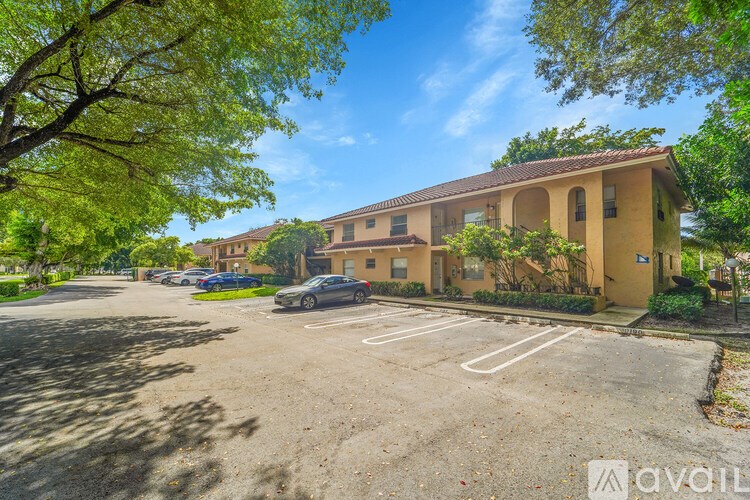 A parking lot in front of a building with a car parked in it.
