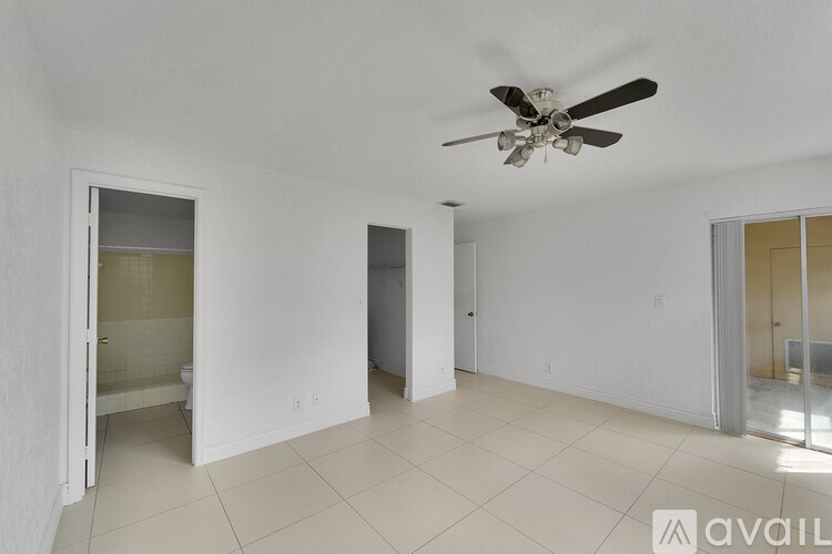 A spacious room with a ceiling fan and tiled flooring.