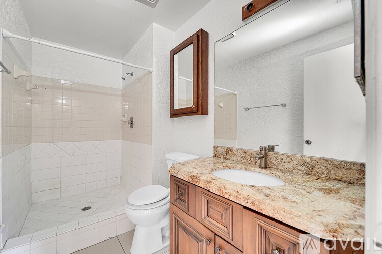 A bathroom with a white toilet and a marble countertop.