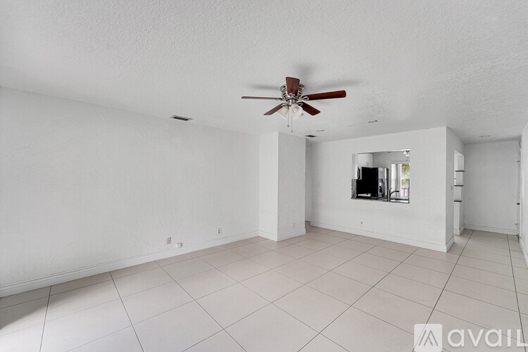 A spacious room with a ceiling fan and a large mirror on the wall.