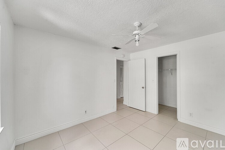 A room with a ceiling fan and tiled flooring.