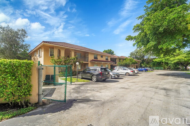 A sunny day at a residential area with a house and cars parked in the driveway.