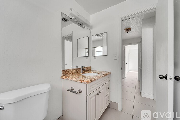 A bathroom with a tub, sink, and mirror.