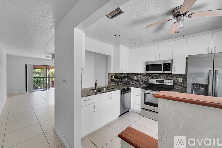 A modern kitchen with white cabinets and a wooden counter.