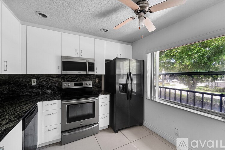 A kitchen with black countertops and white cabinets.