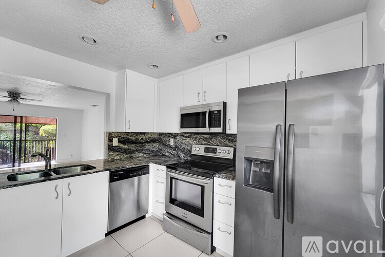 A kitchen with white cabinets and stainless steel appliances.