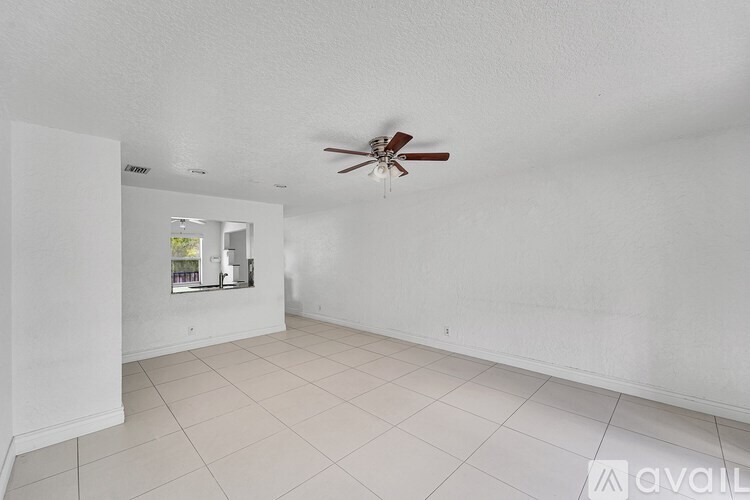 A room with a ceiling fan and a mirror on the wall.