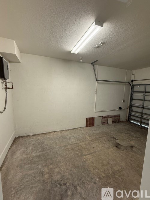 A room with a white wall and a white ceiling with a light on it.