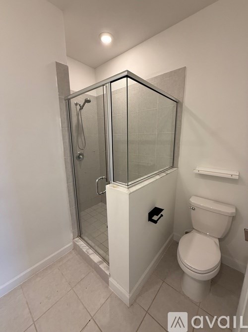 A white toilet in a bathroom with a glass shower door.