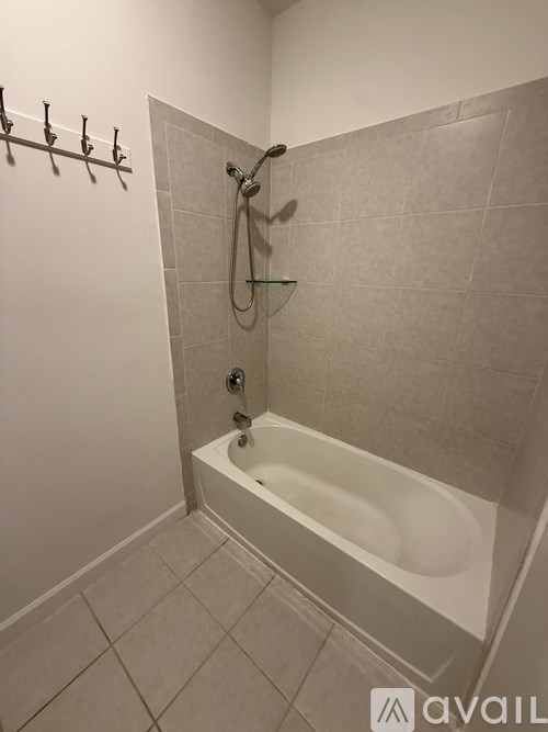 A bathroom with a white tub and a shower head.