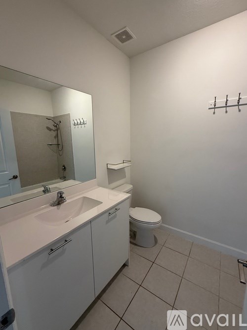 A bathroom with a sink, toilet, and mirror.