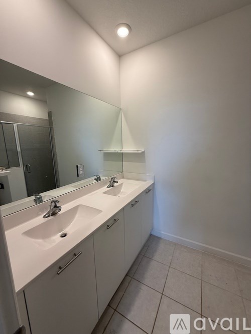 A bathroom with two sinks and a large mirror.