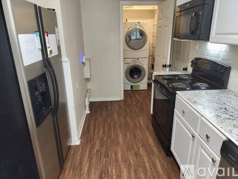 A kitchen with a black fridge, black microwave, and black oven.