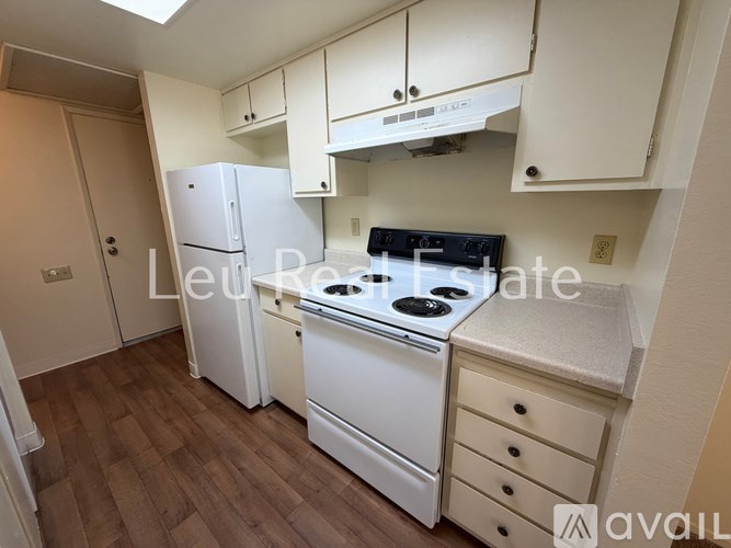 A small kitchen with a white fridge and stove.
