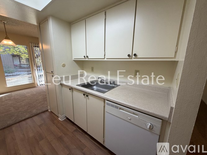 A kitchen with white cabinets and a dishwasher is available for rent.