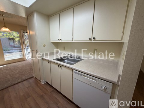 A kitchen with white cabinets and a dishwasher is available for rent.