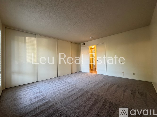 A room with a carpeted floor and a door with a glass panel.
