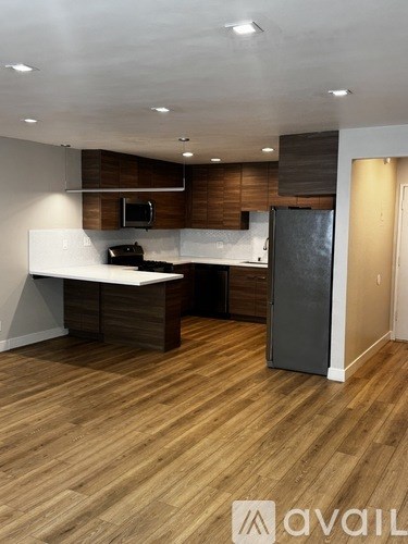 A kitchen with wooden floors and a refrigerator.