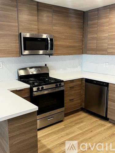 A kitchen with wooden cabinets and a stainless steel oven.