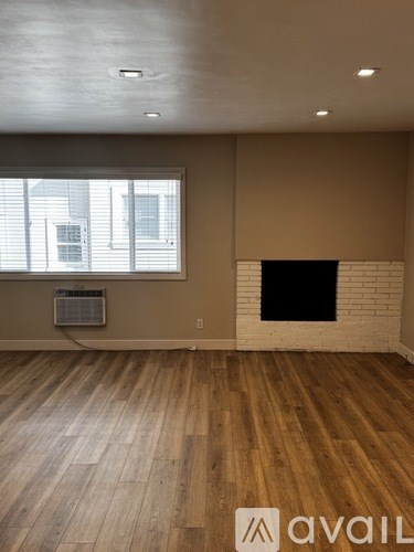 A room with a fireplace and wooden floors.