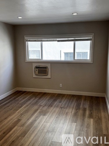 A room with wooden flooring and a window.
