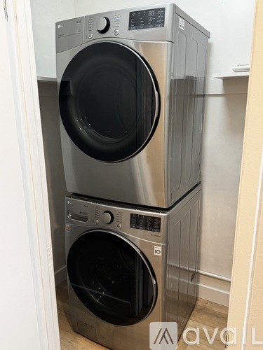 A stacked washer and dryer in a small room.