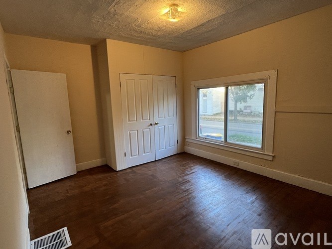 A room with a window, a door, and a wall-mounted light fixture.