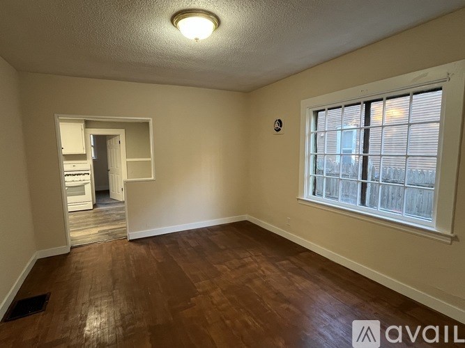 A room with a window and wooden flooring.