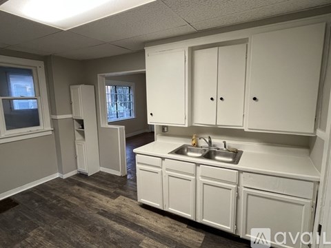 A kitchen with white cabinets and a sink.