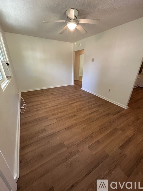 A room with wooden flooring and a ceiling fan.