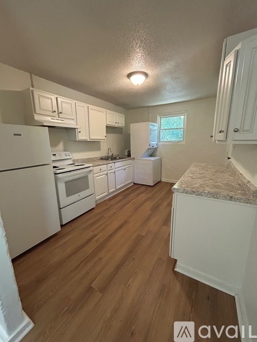 A kitchen with white appliances and cabinets.