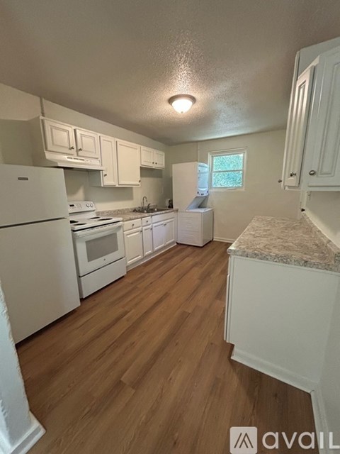 A kitchen with white appliances and cabinets.