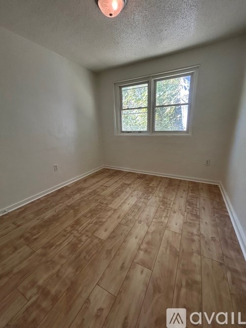A room with wooden flooring and a window.