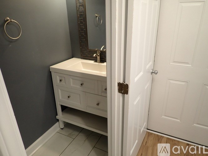 A bathroom with a white sink and a white door.