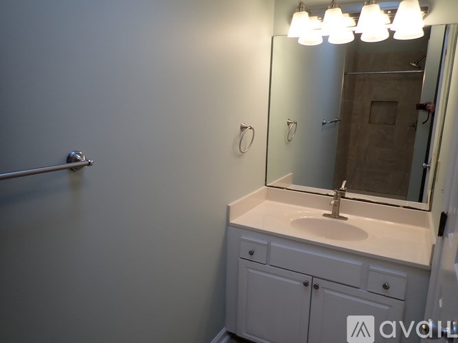 A bathroom with a sink, mirror, and lights.